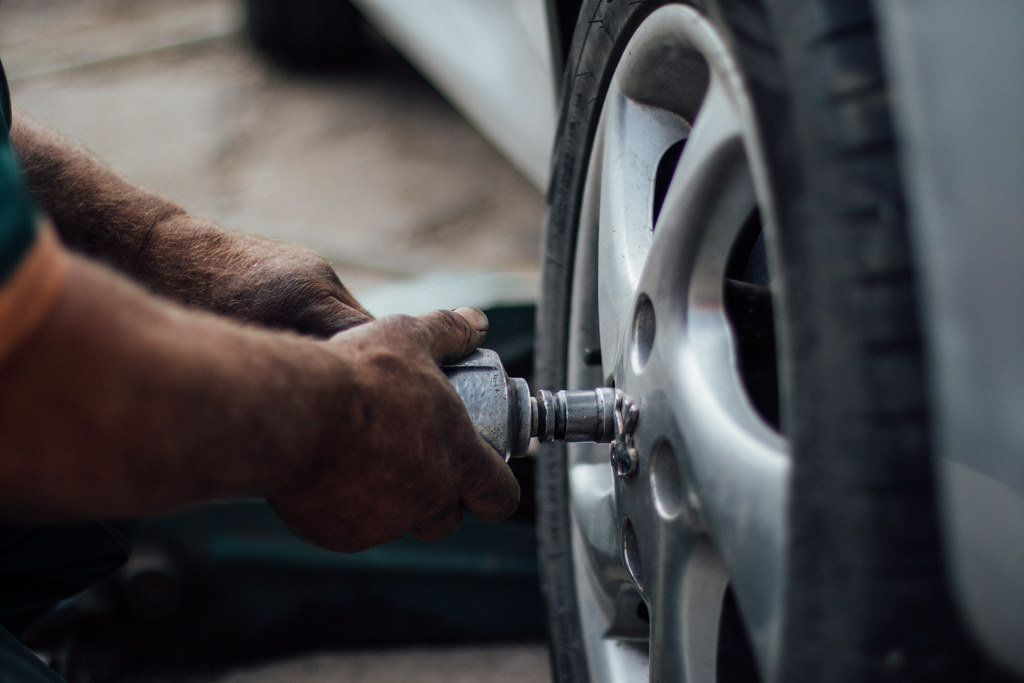 Mechanic taking a wheel off to check the brakes